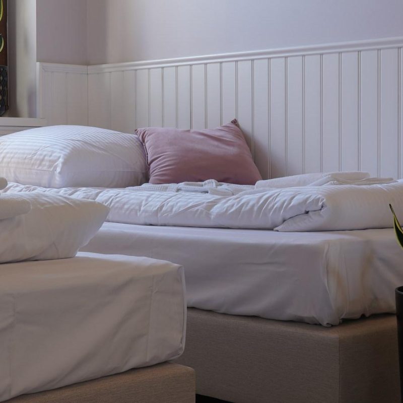 Łóżka ustawione pojedynczo w sypialni apartamentu z tarasem